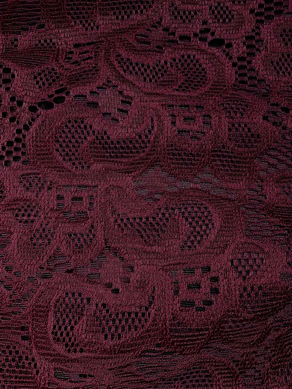 Close-up of a dark red fabric with intricate lace pattern