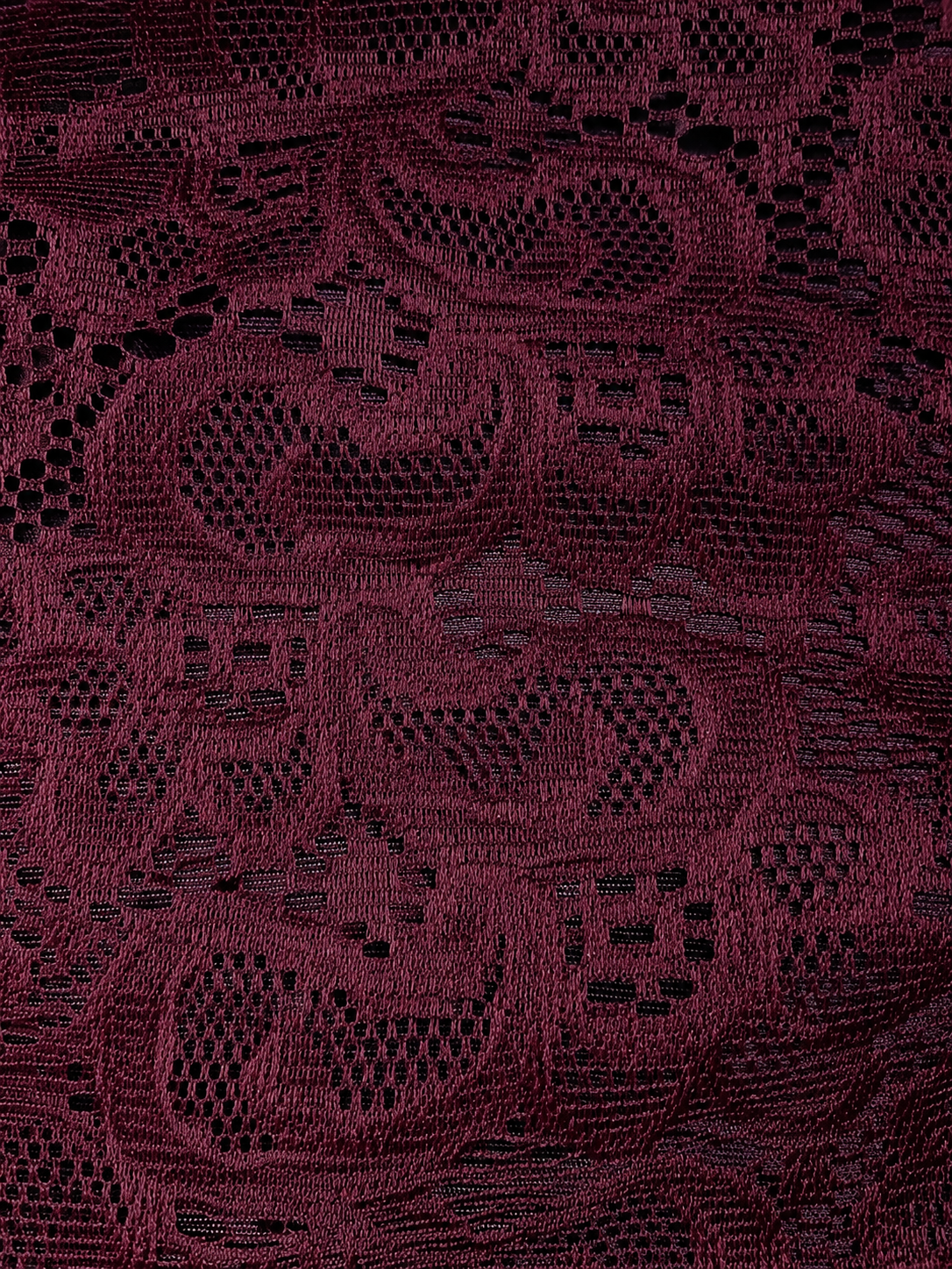 Close-up of a dark red fabric with intricate lace pattern