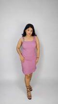 Woman wearing a pink dress against a white background